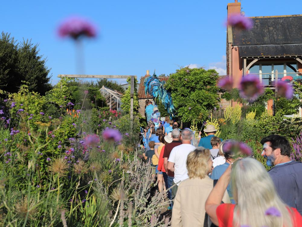 Cast of Rising Waters stand on grass in front of a lake