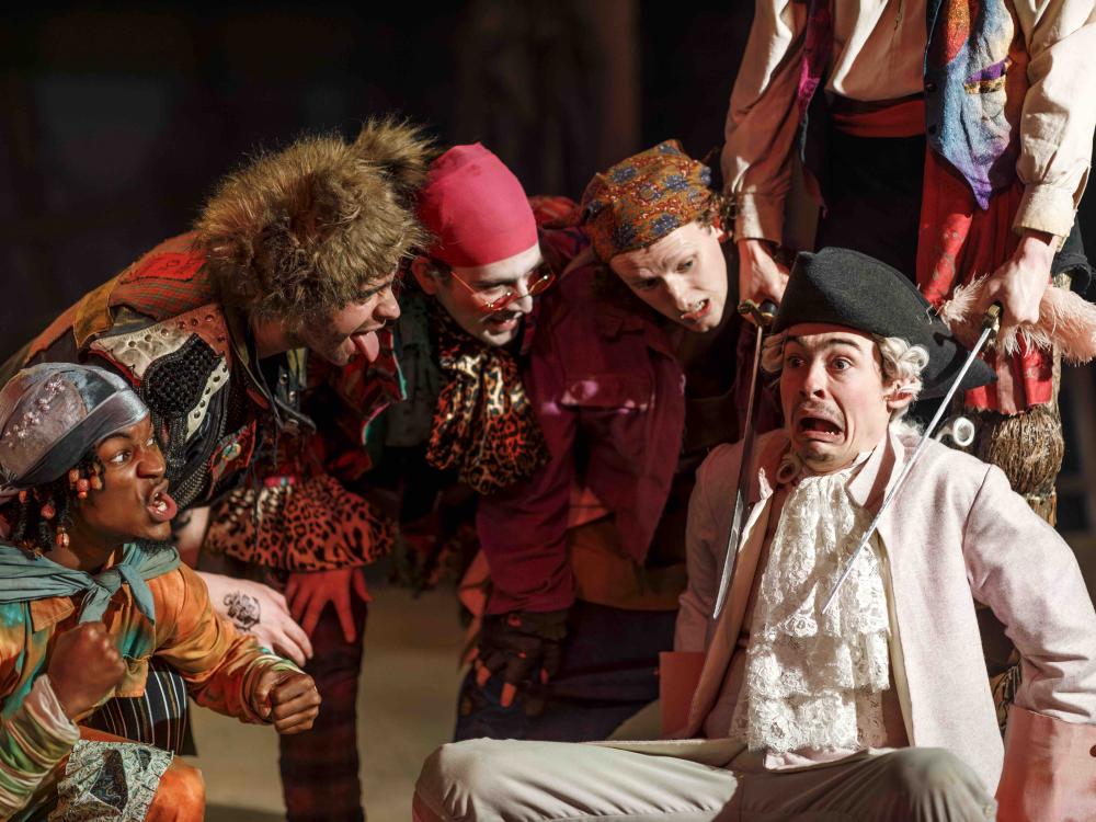 man in pink coat with swords at his neck